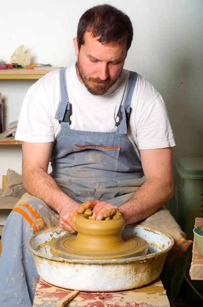 Craftsman making vase from fresh wet clay on pottery wheel. — Stock Photo #9627752