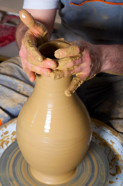 Craftsman making vase from fresh wet clay on pottery wheel — Stock Photo #9627960