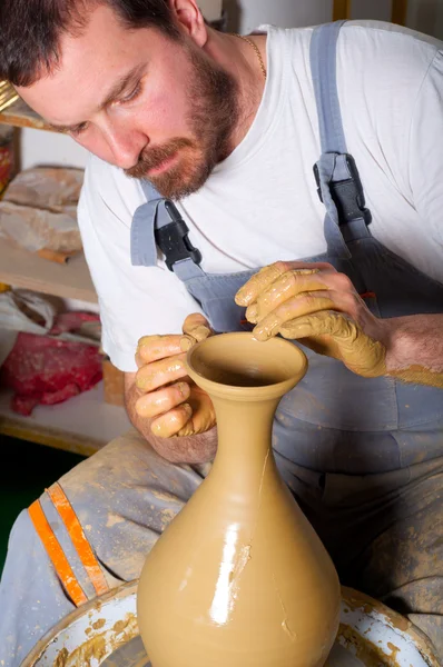 Craftsman making vase from the fresh wet clay on the pottery wheel — Stock Photo #9628378