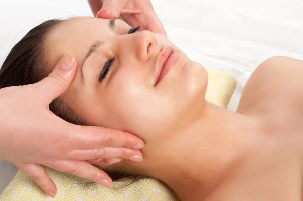 Beautiful young women getting a face massage in massage salon