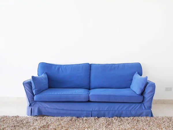 Double couch on a blank wall