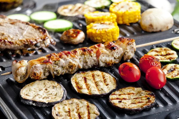Meat skewer and vegetables on electric grill