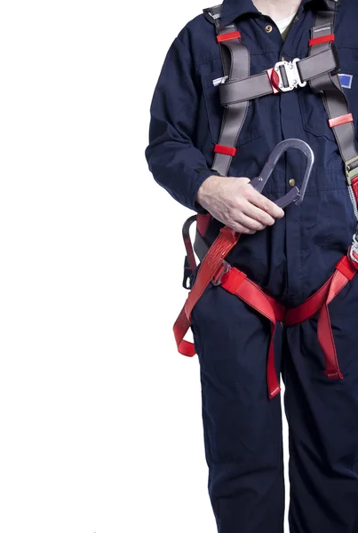 Man wearing coveralls and fall protection harness and lanyard