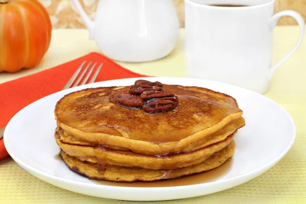Pumpkin pancakes with pecans and syrup.