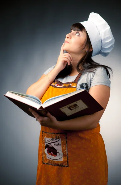 Woman cook holding recipes book and thinking what to cook