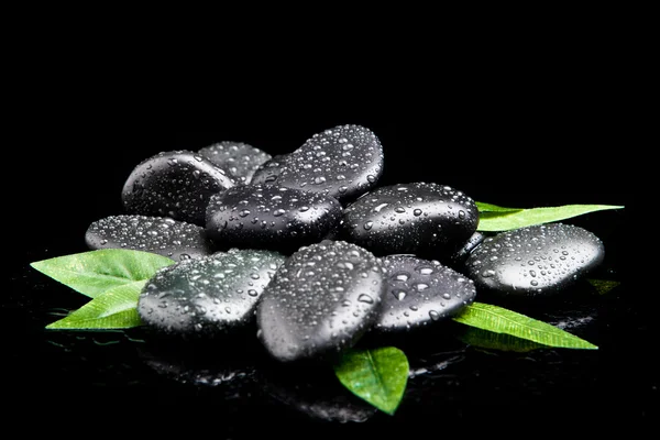 Zen stones and leaves with water drops. leaf and basalt stones