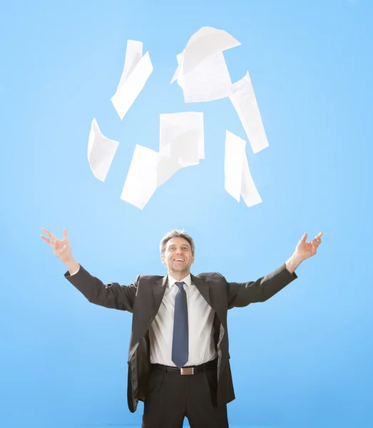 Senior businessman throwing sheets of paper