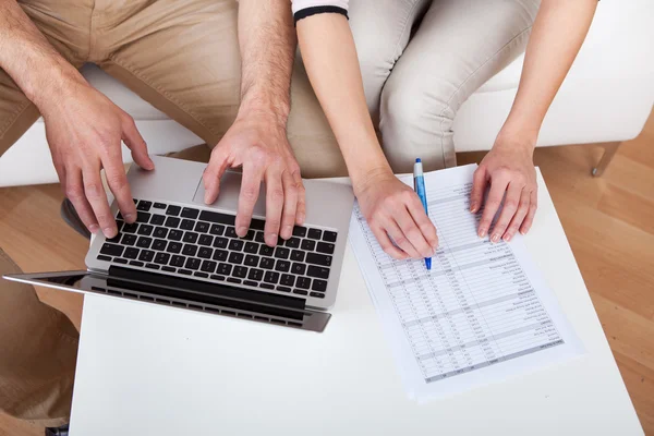 Young couple doing finances at laptop