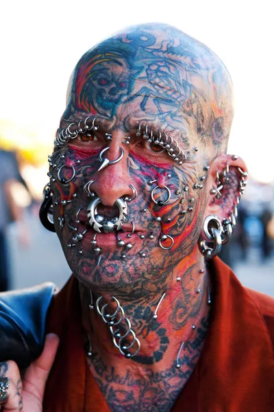 Face with tattoos and piercings