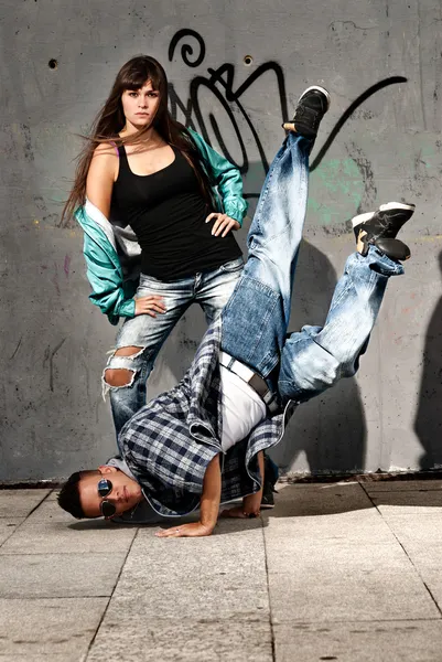 Young urban couple dancers hip hop dancing urban scene