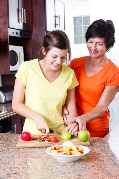Mother teaching teen daughter cooking