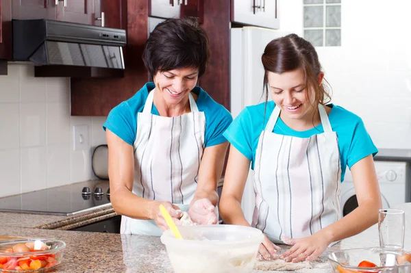 Happy mother and teen daughter baking