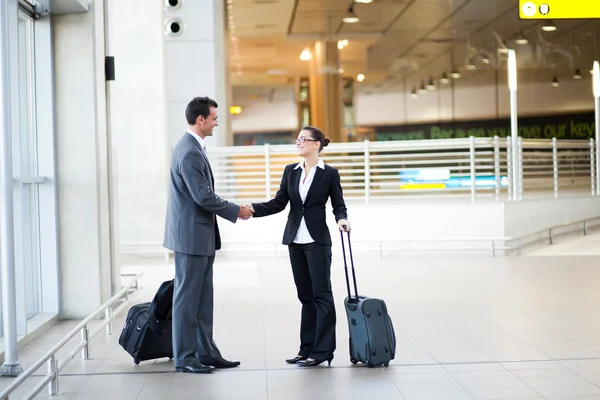 Businessman and businesswoman meeting at airport