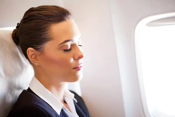 Businesswoman resting on airplane