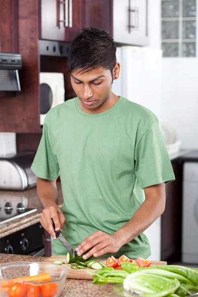 Young indian man cooking in kitchen