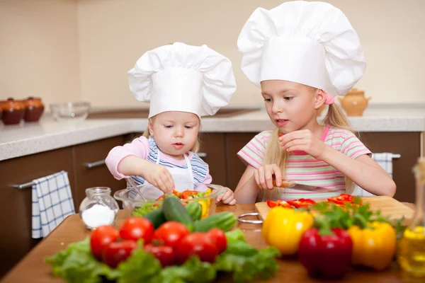 Two little girls preparing healthy food on kitchen