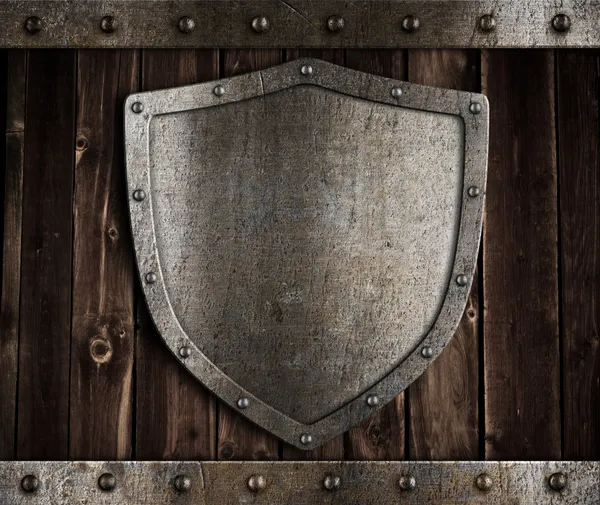 Aged metal shield on wooden medieval gates