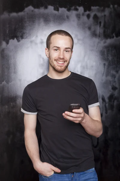 Smiling guy with smartphone typing SMS