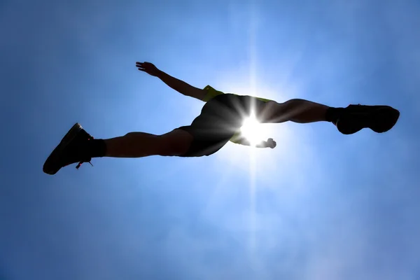 The Silhouette of runner acrossing sky with sunlight background