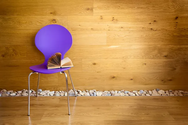 Purple chair with opened book next wooden wall / modern interior — Stock Photo #10432692