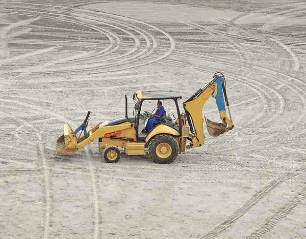 An excavator truck parked on the sand