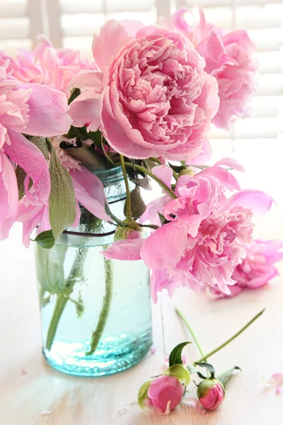 Pink peonies in glass jar