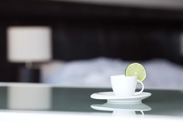 Tea with lemon on the background of the bed and the lamp