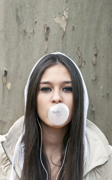 Portrait of young girl blowing bubble gum
