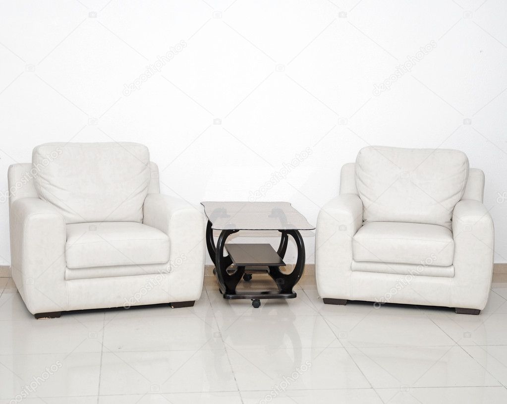 Detail van een moderne woonkamer met witte leunstoel en glas cof ...