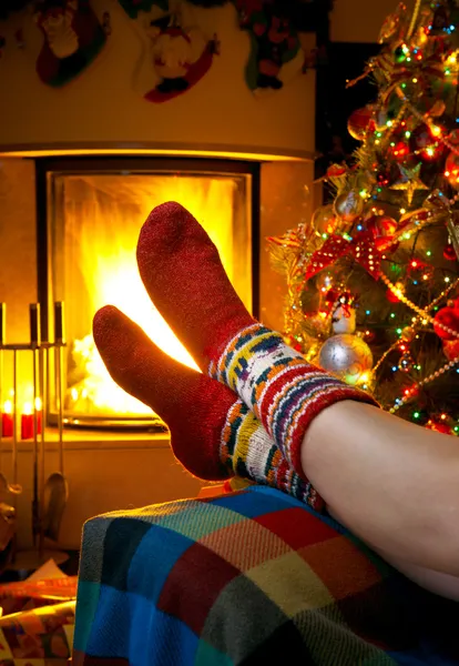 Girl resting in a home with a burning fireplace and Christmas tr