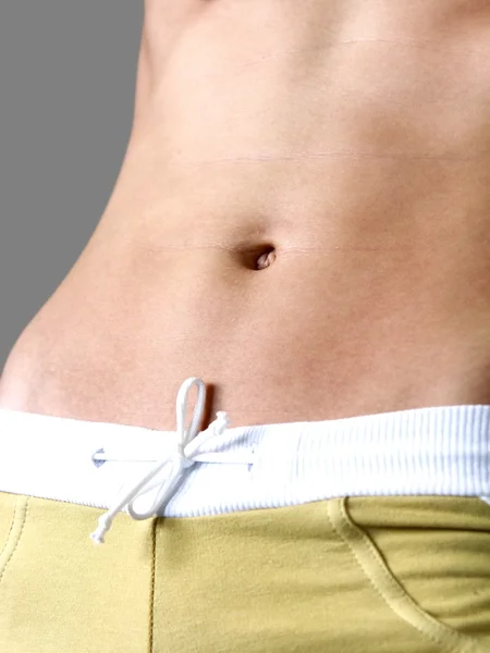 Healthy woman stomach in shorts. Exercises and diet concept. Iso