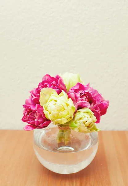 Tied tulips in a glass vase on table and empty space for your te