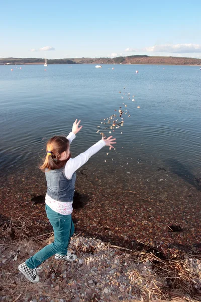 Young girl throwing stones