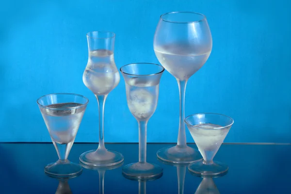 Five wineglasses with ice and water