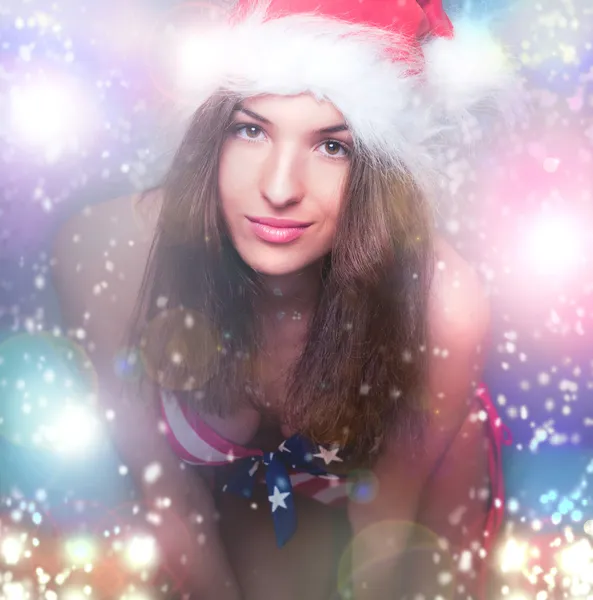 20-25 years old beautiful woman in christmas hat and swimsuit wi