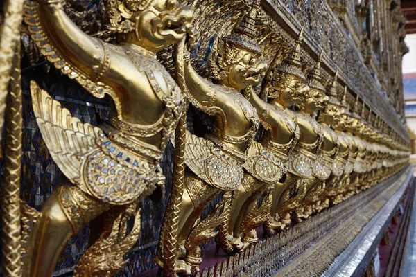 Thailand, Bangkok, Imperial City, Imperial Palace, golden statues on the external wall of a Buddhist temple