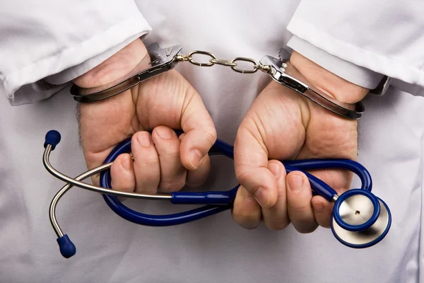 Doctor with stethoscope and handcuffs