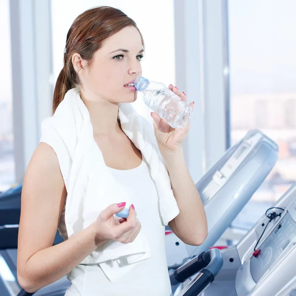Young woman at the gym exercising. Drink