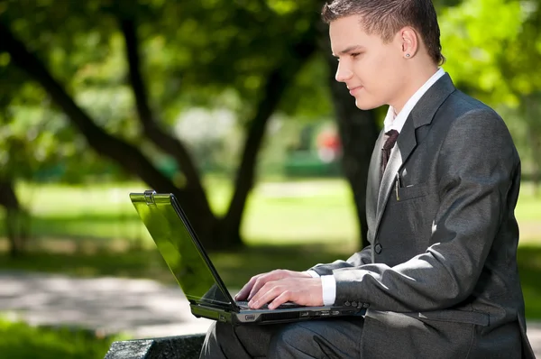 Business man work on notebook at park. Student