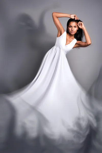 一个美丽的黑皮肤的女人穿白裙子的肖像 - 图库