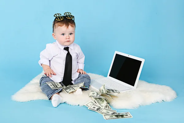 Small young businessman with a serious face with money and a lap
