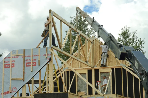 Roof framing with worker and crane