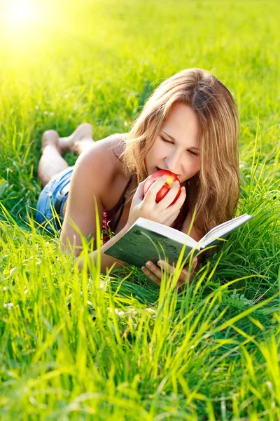 Happy Woman Reading Book with Apple in Hand