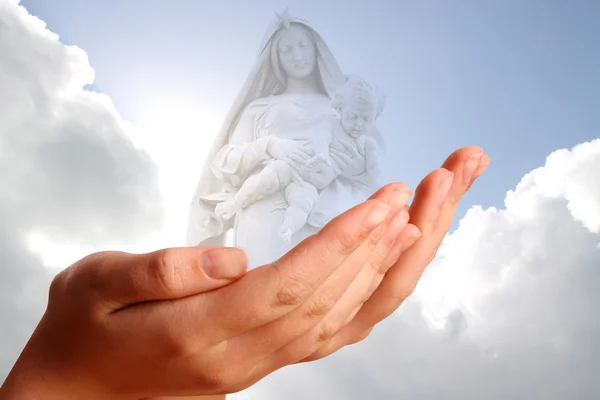 Two young hands offering to mother Mary