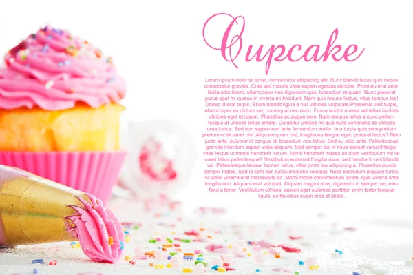 Cupcake and decorating bag on a white table with colorful sugar
