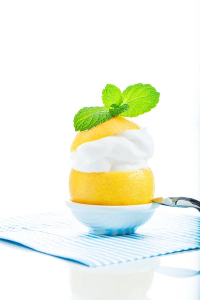 A fresh lemon with lemon cream and mint on the top on white back