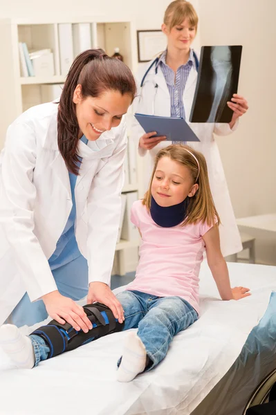 Pediatrician examining girl broken leg