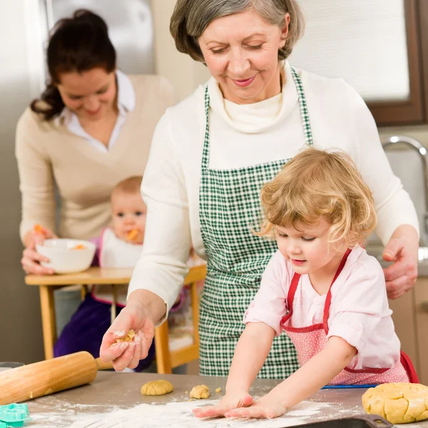 Grandmother with little girl prepare dough