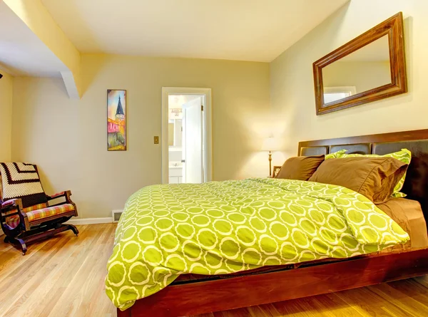 Modern bedroom with bright green bed spread.