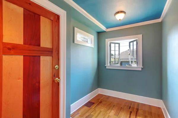 Cutom wood door in blue empty room with open window.